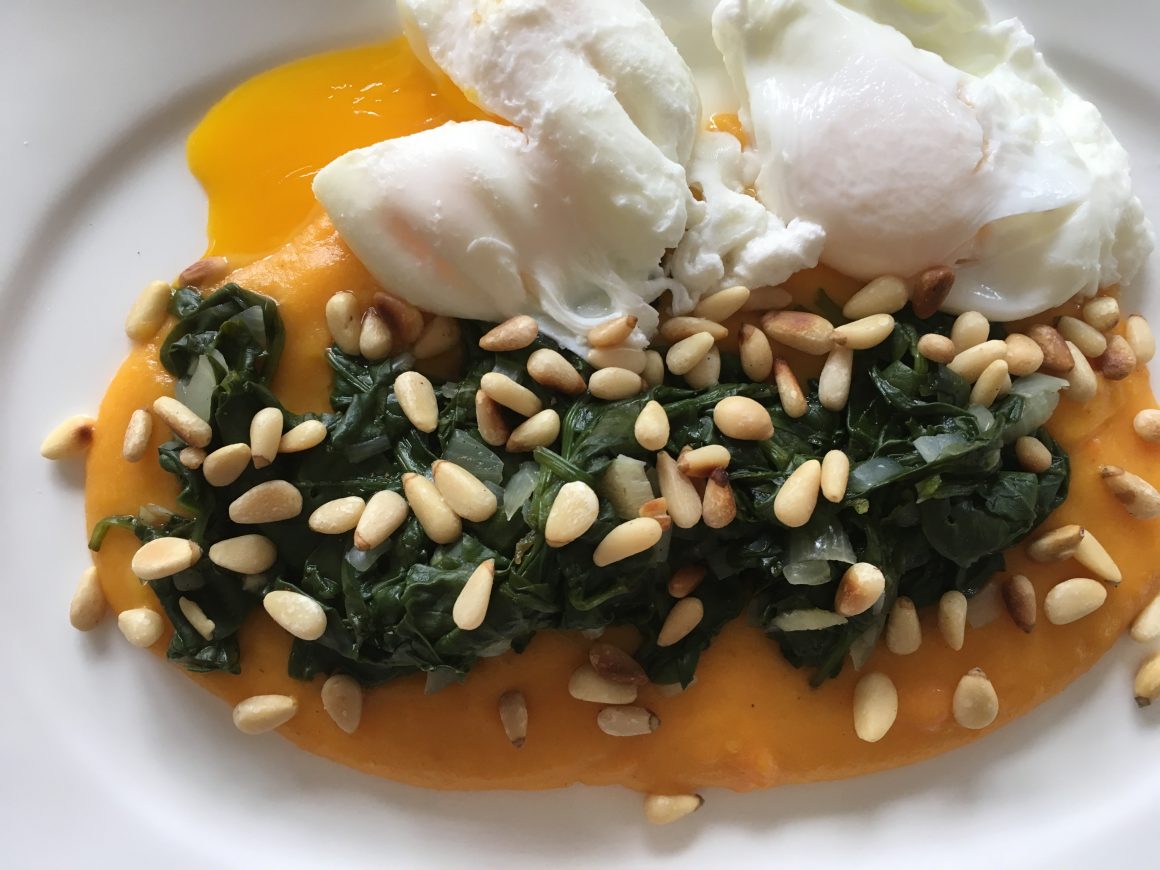 Würziger Baby-Spinat mit Pinienkernen auf Karotten-Kartoffel-Stampf mit pochierten Eiern